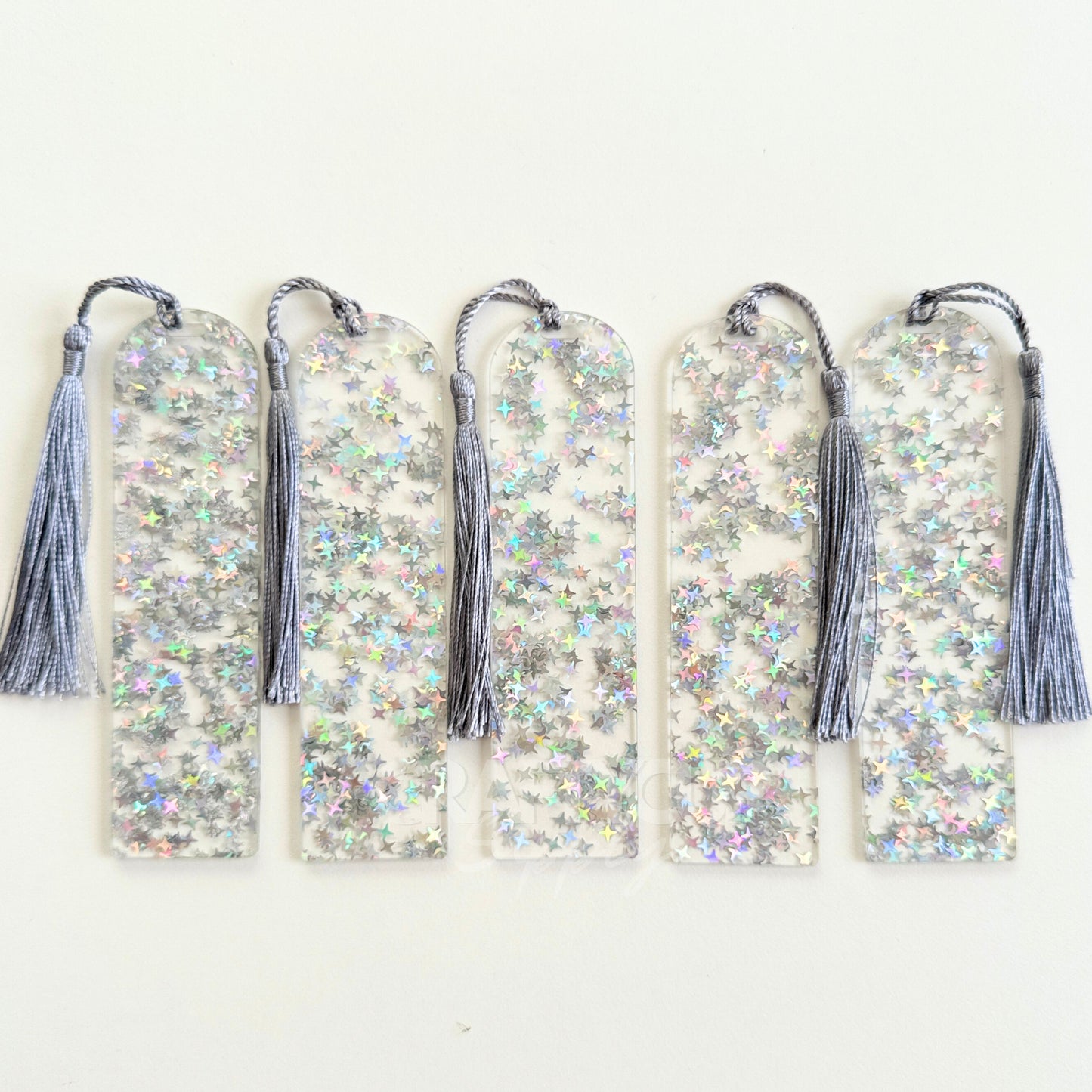 Clear acrylic bookmark blank filled with internal silver star glitter, measuring 12x3.2cm with a smooth finish, pre-cut hole, and tassel – perfect for UV DTF, vinyl, and custom designs.