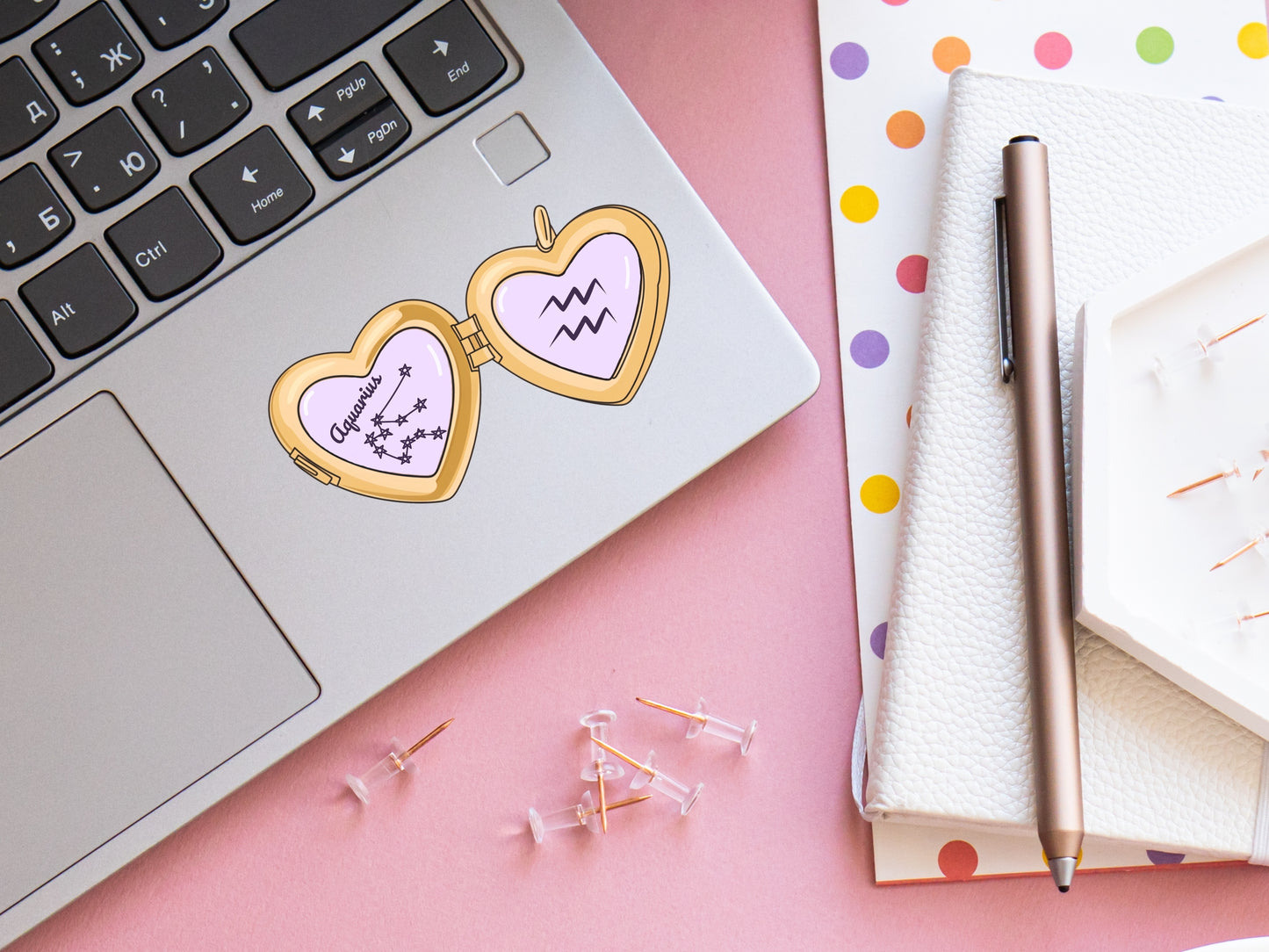 a cute trending and popular PNG digital download design of a gold love heart locket featuring a zodiac star sign and constellation symbol, finished with a purple lilac bow.  Can be used to create physical stickers or use for sublimation on clothing such as t shirts, jumpers and canvas bags