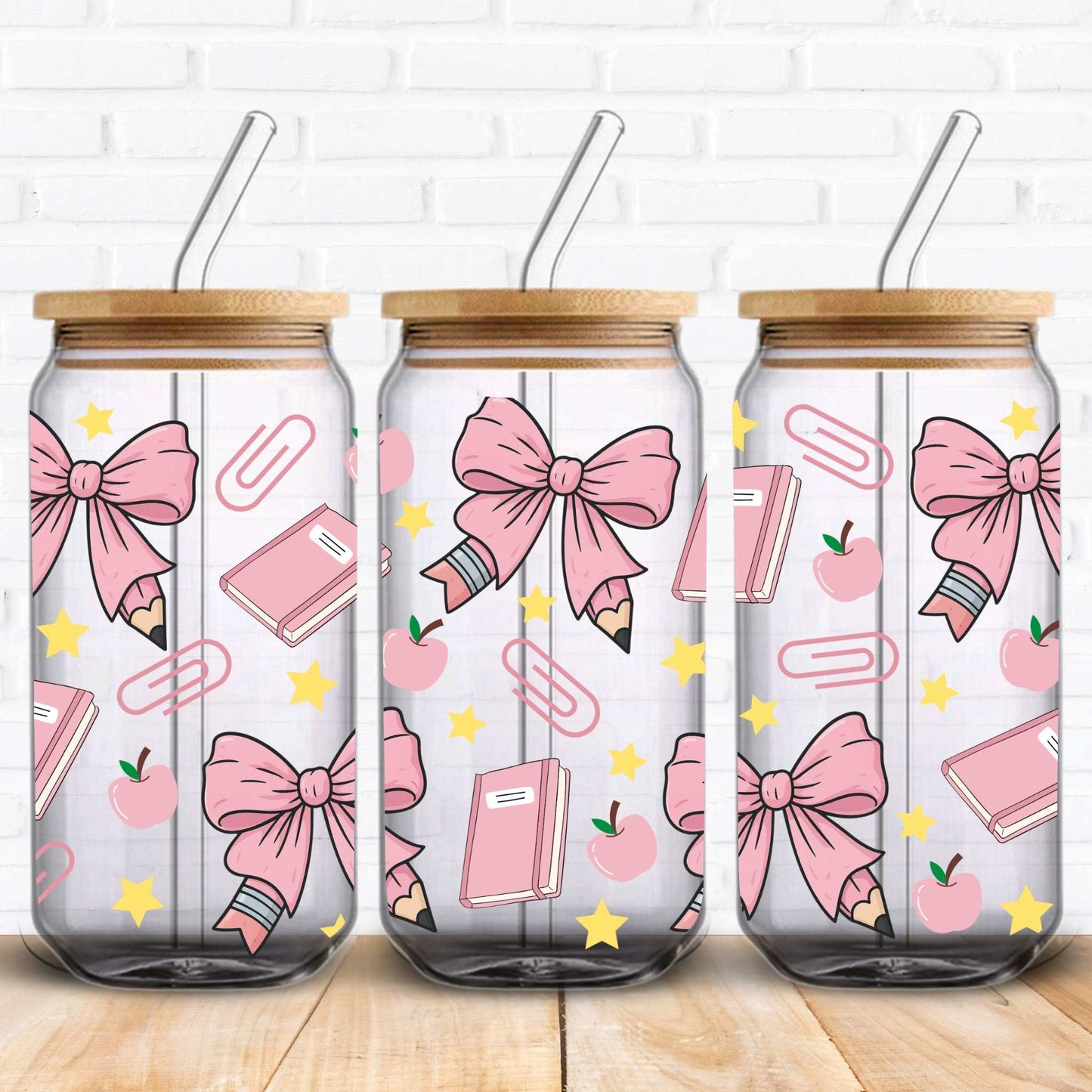 Seamless kawaii-style pattern designed for a 16oz Libbey glass can, featuring pastel pink bows tied around pencils, pink notebooks, apples, paperclips, and yellow stars on a black background. The elements are illustrated with a soft, hand-drawn texture, creating a playful and school-themed aesthetic.