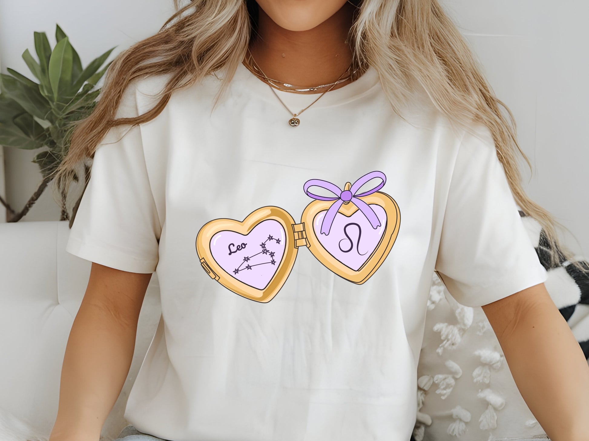 a cute trending and popular PNG digital download design of a gold love heart locket featuring a zodiac star sign and constellation symbol, finished with a purple lilac bow.  Can be used to create physical stickers or use for sublimation on clothing such as t shirts, jumpers and canvas bags