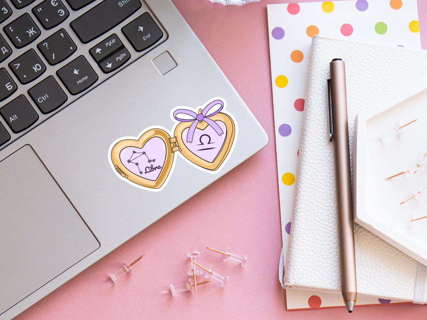 a cute trending and popular PNG digital download design of a gold love heart locket featuring a zodiac star sign and constellation symbol, finished with a purple lilac bow.  Can be used to create physical stickers or use for sublimation on clothing such as t shirts, jumpers and canvas bags