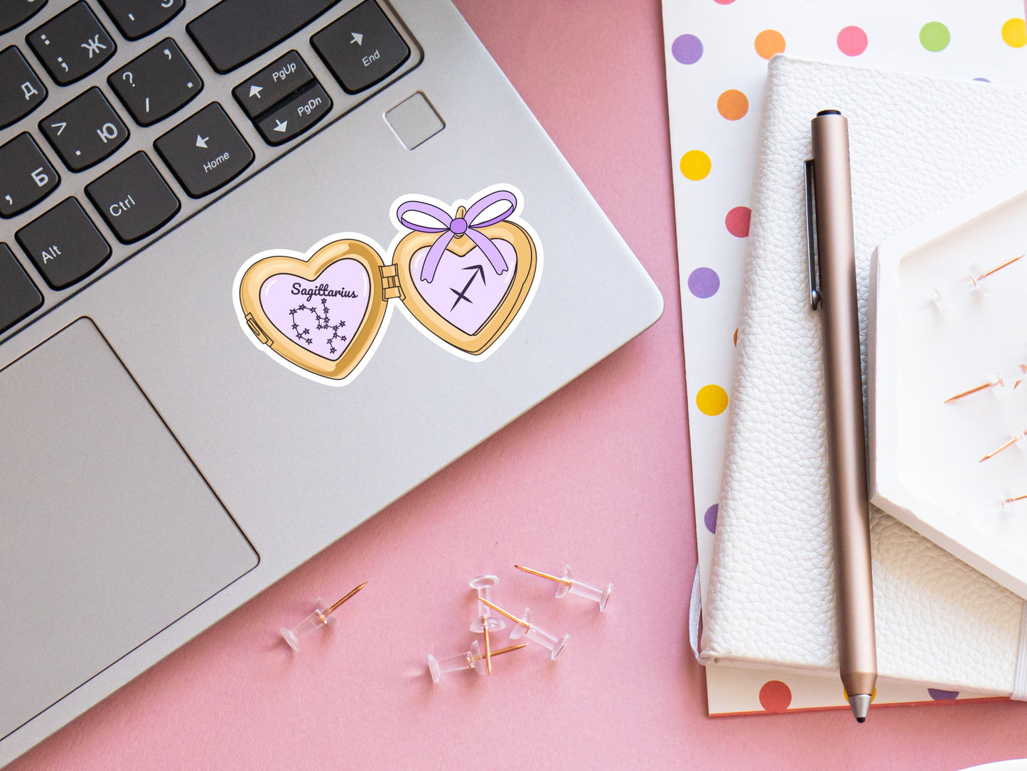 a cute trending and popular PNG digital download design of a gold love heart locket featuring a zodiac star sign and constellation symbol, finished with a purple lilac bow.  Can be used to create physical stickers or use for sublimation on clothing such as t shirts, jumpers and canvas bags