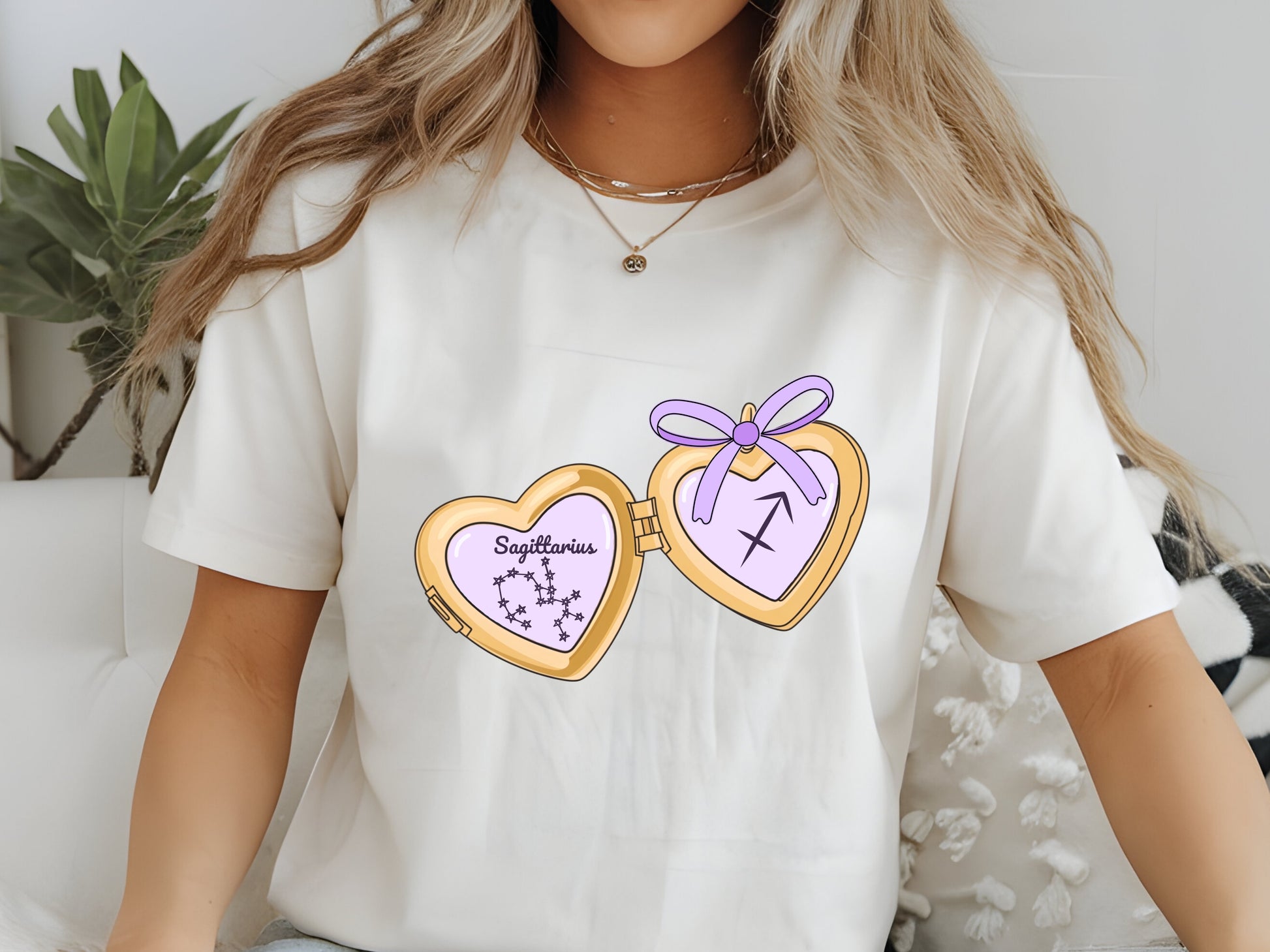 a cute trending and popular PNG digital download design of a gold love heart locket featuring a zodiac star sign and constellation symbol, finished with a purple lilac bow.  Can be used to create physical stickers or use for sublimation on clothing such as t shirts, jumpers and canvas bags