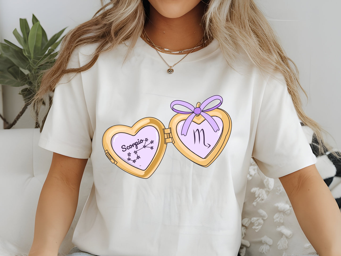 a cute trending and popular PNG digital download design of a gold love heart locket featuring a zodiac star sign and constellation symbol, finished with a purple lilac bow.  Can be used to create physical stickers or use for sublimation on clothing such as t shirts, jumpers and canvas bags