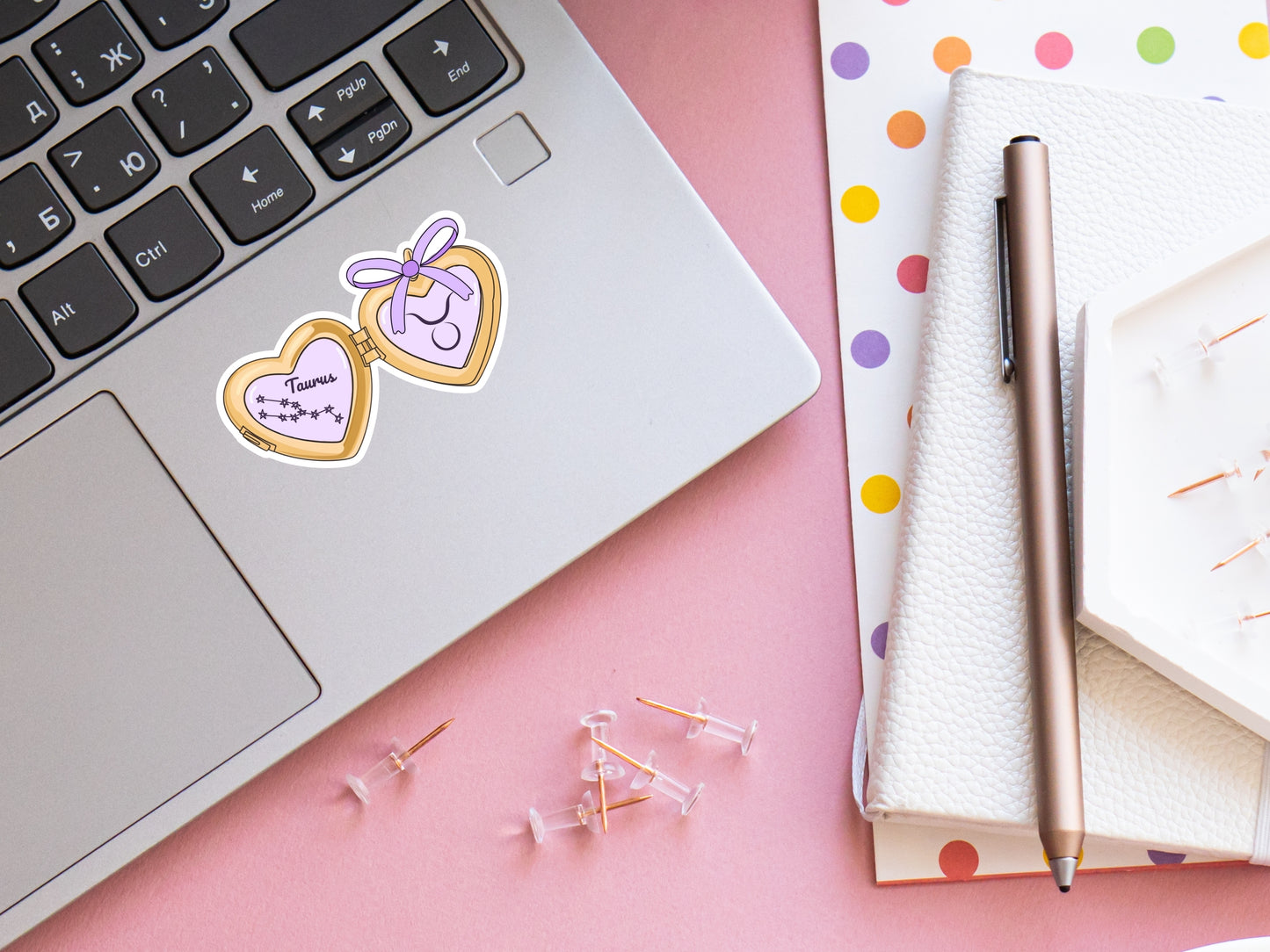 a cute trending and popular PNG digital download design of a gold love heart locket featuring a zodiac star sign and constellation symbol, finished with a purple lilac bow.  Can be used to create physical stickers or use for sublimation on clothing such as t shirts, jumpers and canvas bags