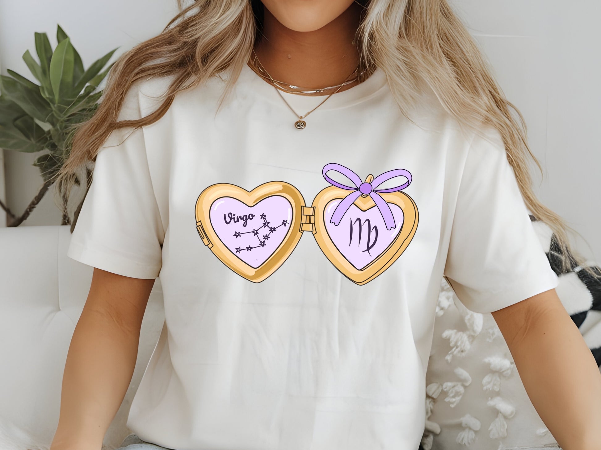 a cute trending and popular PNG digital download design of a gold love heart locket featuring a zodiac star sign and constellation symbol, finished with a purple lilac bow.  Can be used to create physical stickers or use for sublimation on clothing such as t shirts, jumpers and canvas bags