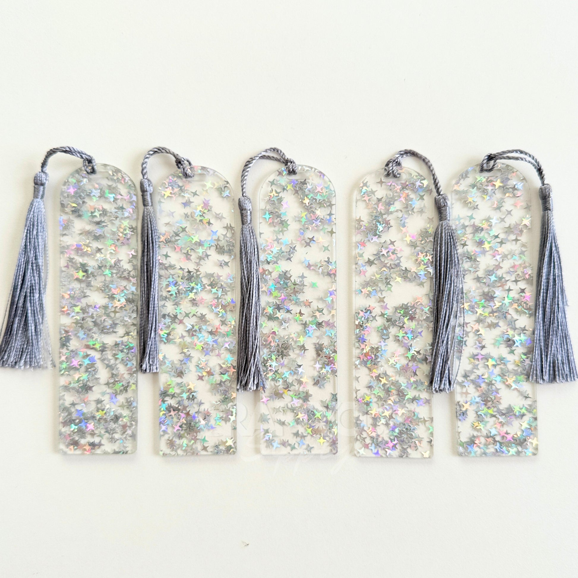 Clear acrylic bookmark blank filled with internal silver star glitter, measuring 12x3.2cm with a smooth finish, pre-cut hole, and tassel – perfect for UV DTF, vinyl, and custom designs.