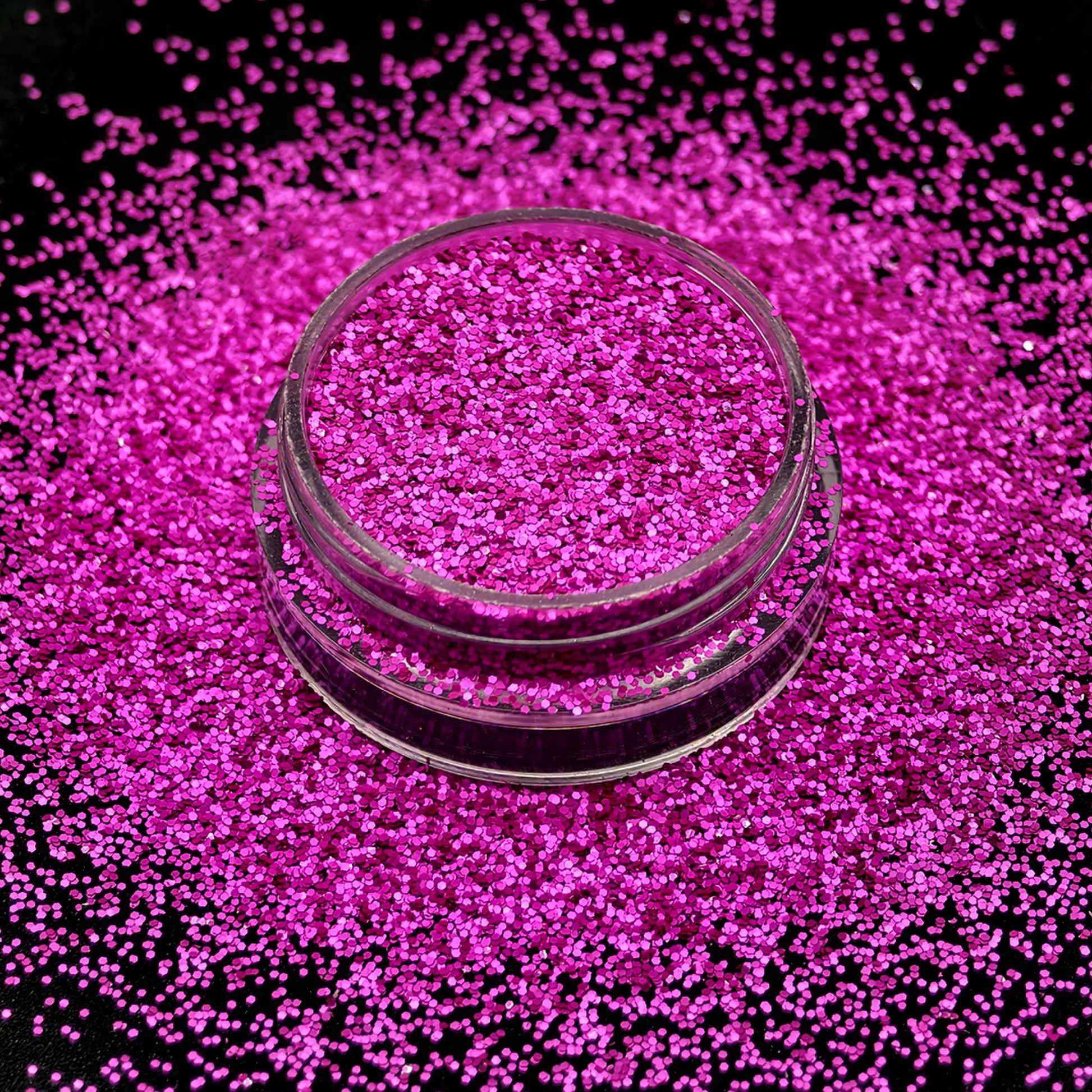 Pink glitter in a clear container on a black background