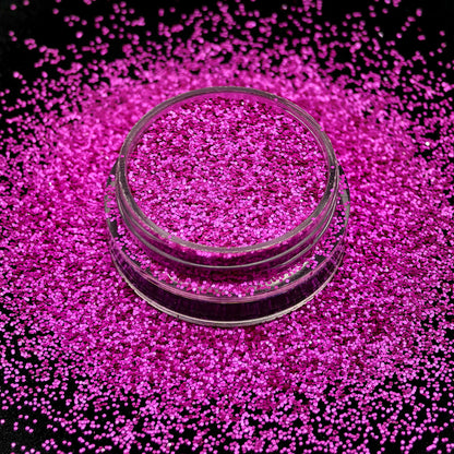 Pink glitter in a clear container on a black background