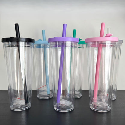 Set of clear tumblers with colorful lids and straws on a black surface.