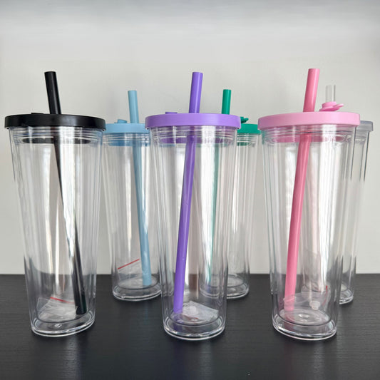 Set of clear tumblers with colorful lids and straws on a black surface.