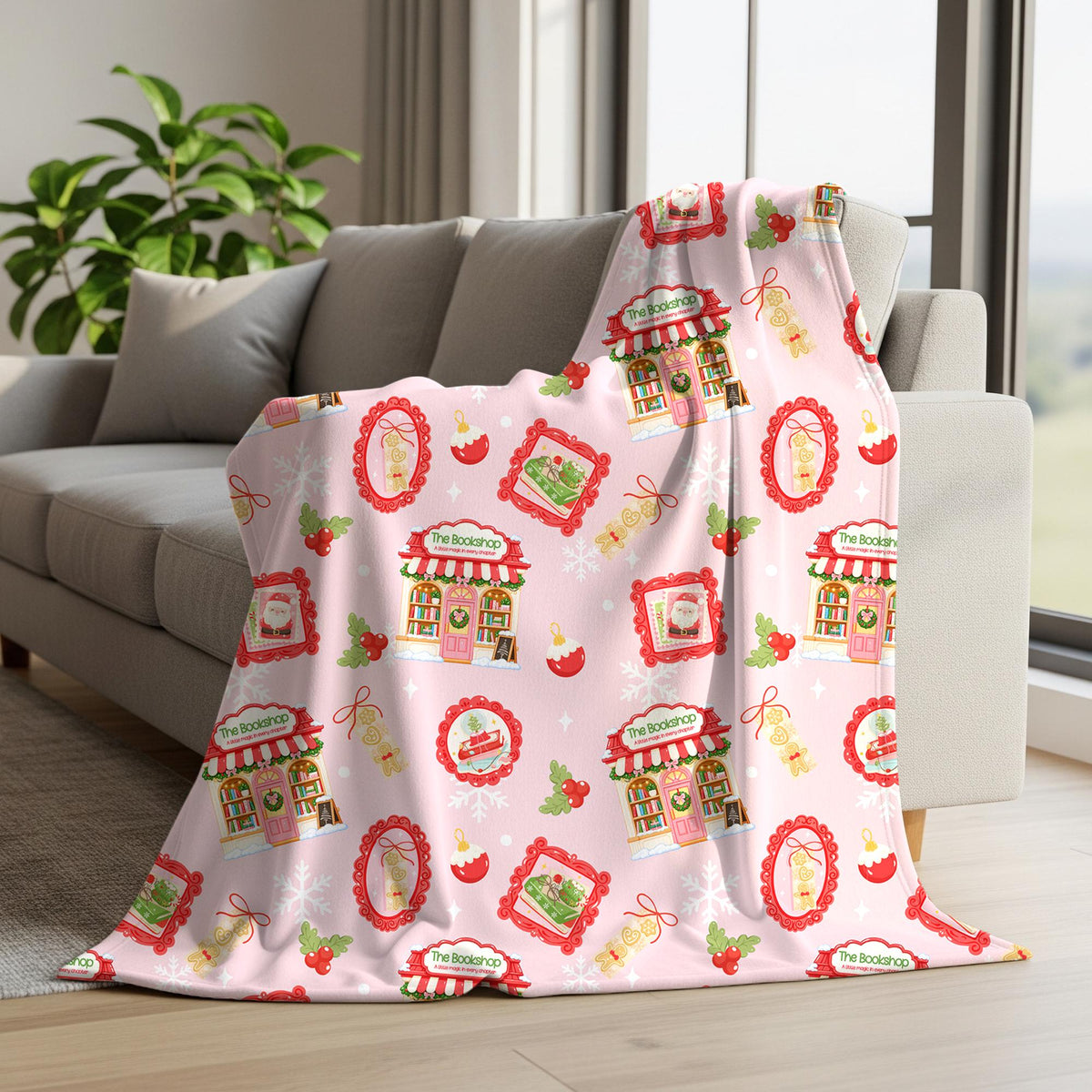 A pink throw blanket with a colorful Christmas market pattern is draped over a gray sofa in a living room setting.