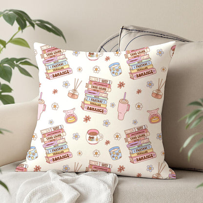 Pastel reading club digital paper displayed on a decorative cushion featuring romance and fantasy books, coffee cups, candles and daisies.