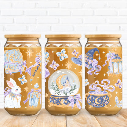 Winter Witch magical illustration featuring a blue and gold spellbook, celestial witch hat, crystal wand, enchanted snow globe, potion bottle, white rabbit, moonlit cauldron, lavender bows and golden stars in a pastel winter fantasy theme.