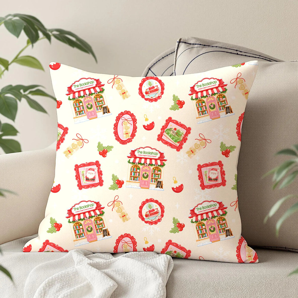 Christmas bookstore seamless digital paper displayed on a decorative cushion featuring pastel pink festive illustrations, holly, red baubles and snowflakes.