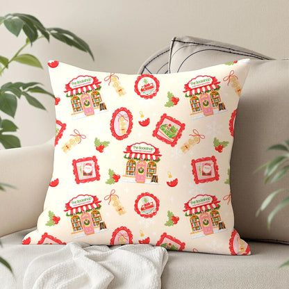 Christmas bookstore seamless digital paper displayed on a decorative cushion featuring pastel pink festive illustrations, holly, red baubles and snowflakes.