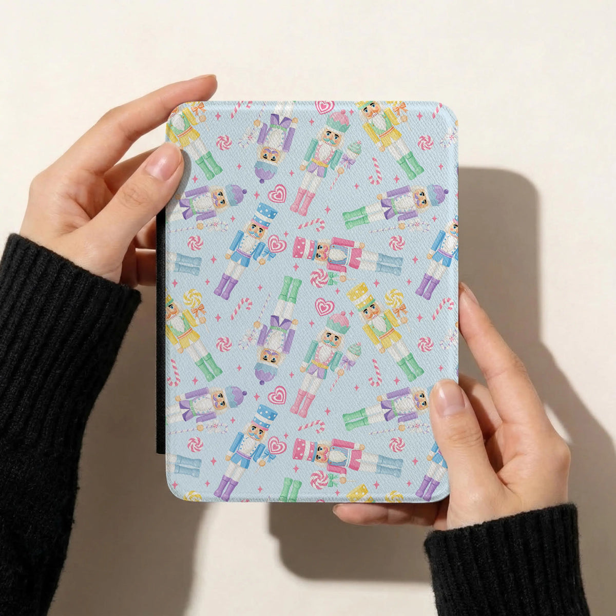 Colourful pastel Christmas nutcracker digital paper displayed on a Kindle case with pink, blue, mint, purple and yellow toy soldiers.