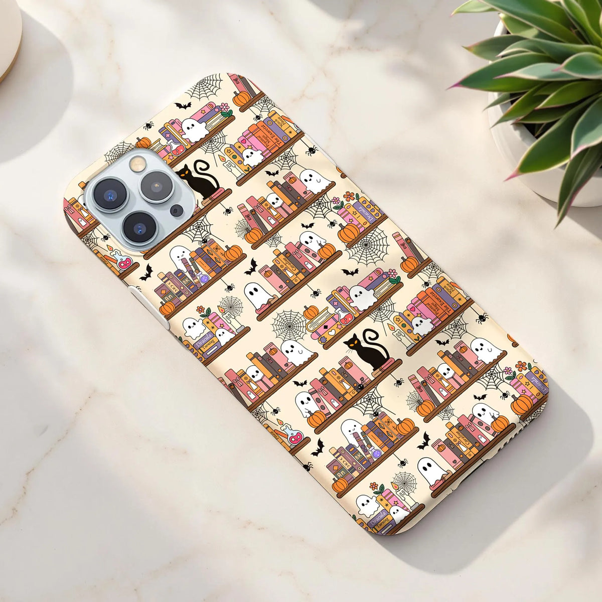 Cute Halloween bookish seamless digital paper displayed on a phone case with spooky bookshelves, friendly ghosts, black cats and pumpkins.