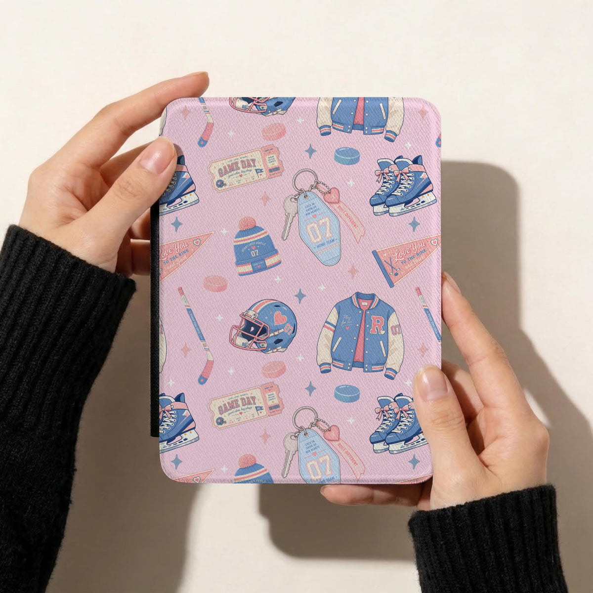 Heated Rivalry inspired hockey romance pattern displayed on a Kindle cover with pastel ice skates, varsity jackets, hockey pucks and pink bows.