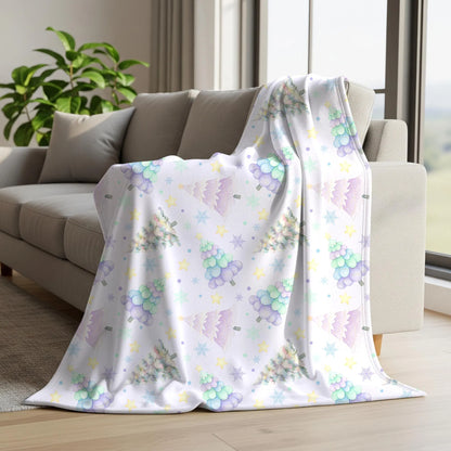 Soft pastel Christmas tree digital paper displayed on a fleece blanket with colourful watercolour trees, snowflakes and stars.