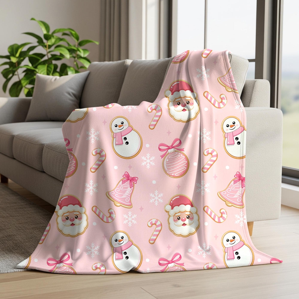 Pink Christmas cookie seamless pattern displayed on a fleece blanket with Santa faces, snowmen, candy canes, pink bells and snowflakes.