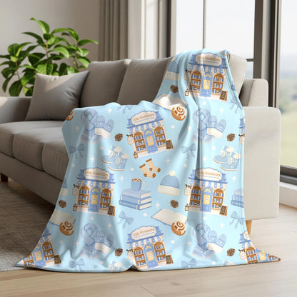 Cozy winter bookish seamless pattern on a fleece blanket featuring blue bookstores, books, scarves and hot cocoa.