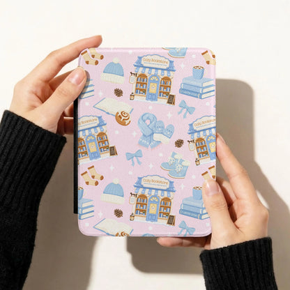 Pink winter reading seamless pattern displayed on an e-reader case with cozy bookstores, books, blue bows and winter accessories.