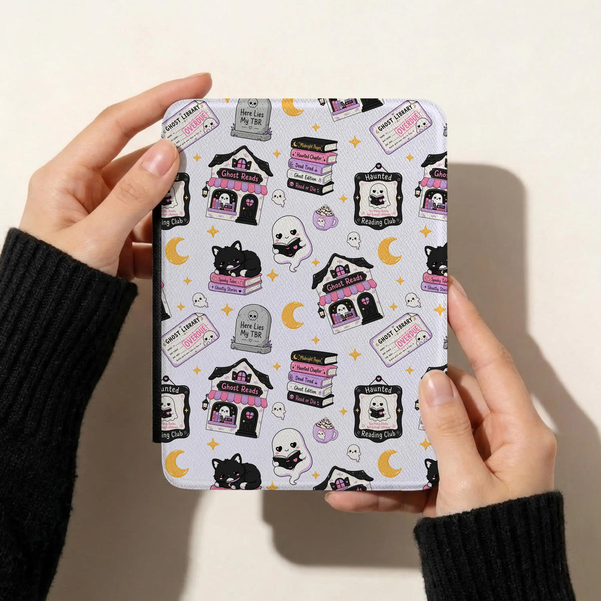 Spooky bookish seamless pattern displayed on a Kindle cover featuring cute reading ghosts, black cats, haunted bookshops and purple Halloween illustrations.